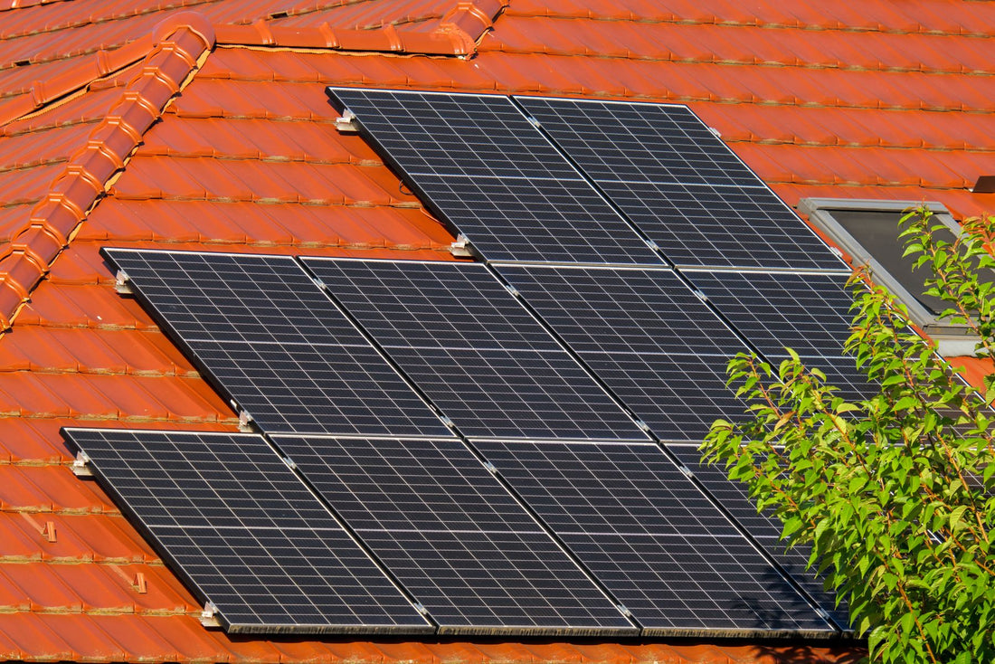Zonnepanelen op een rood pannendak, met zichtbare ruimte onder de panelen