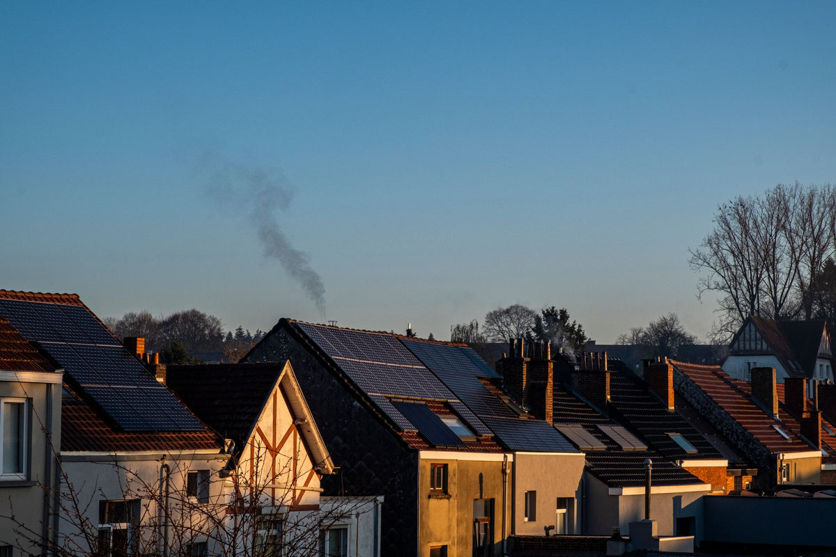 Rij daken met zonnepanelen bij zonsondergang